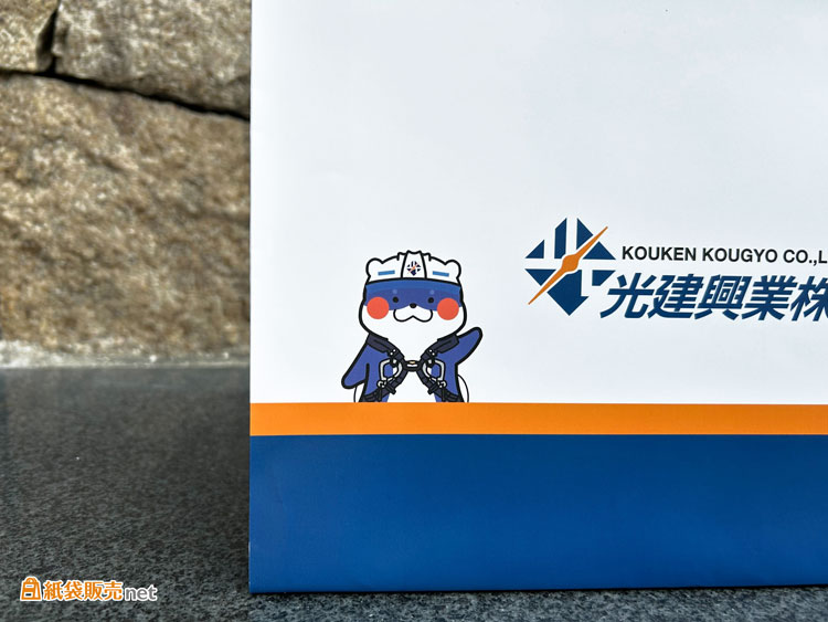 ブルーとオレンジ、それぞれのカラーをまとったキャラクターが紙袋の左右に