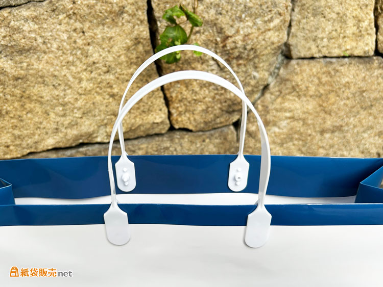 持ち手には、紙袋の上部を閉じることができる「ハッピータック」を採用