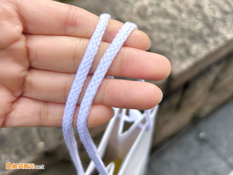 紙袋の持ち手は人気ナンバーワンの「アクリルスピンドル紐」