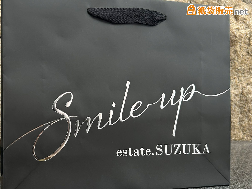 筆記体を使った「Smile up」のロゴを大きく配置したオリジナル紙袋